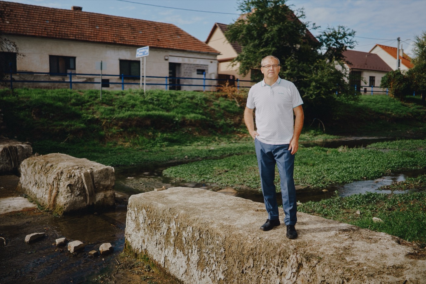 Jaroslav Mareček stojí na kamennom múriku v koryte potoka Teplica